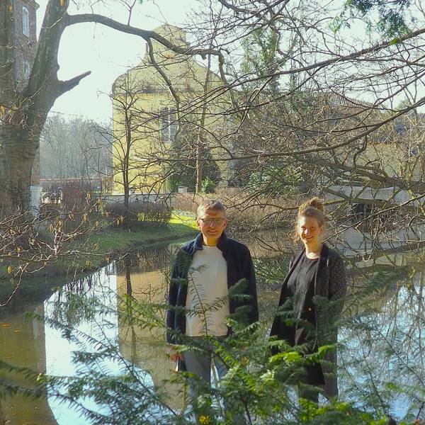 Dorothee Lindenbaum und Stefan Bergner (l.) stehen am Wassgeraben, in dem sich die Burg Flamersheim spiegelt.