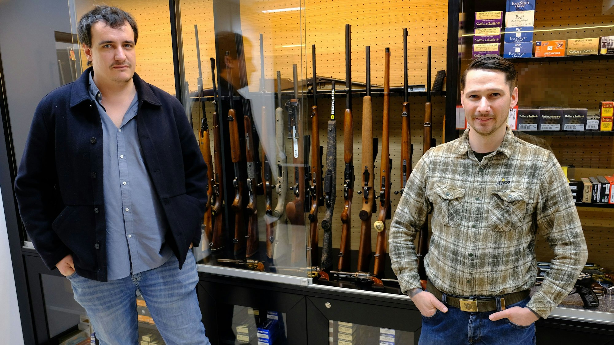 Richard Stamm und Lucas Beier stehen im ehemaligen Dorfladen von Tondorf vor einer Vitrine mit Waffen und Munition.