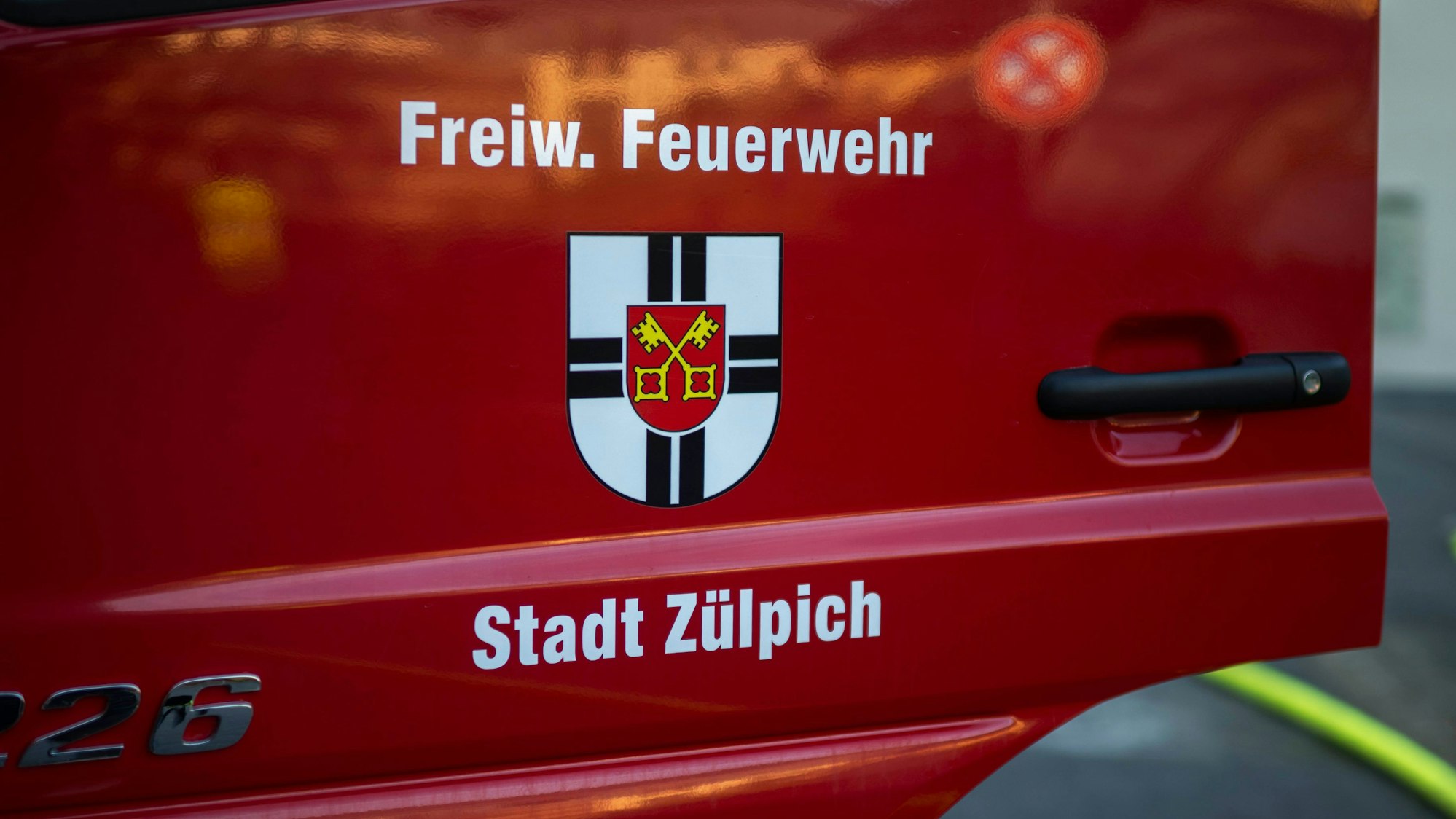 Das Bild zeigt eine geöffnte Fahrertür an einem Feuerwehrfahrzeug der Zülpicher Wehr.