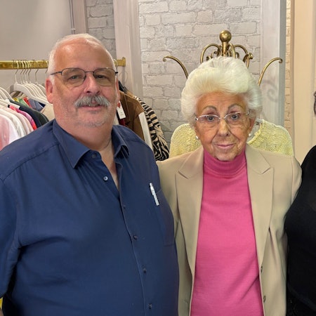 Auf dem Bild sind zwei Frauen und ein Mann in einer Boutique zu sehen.