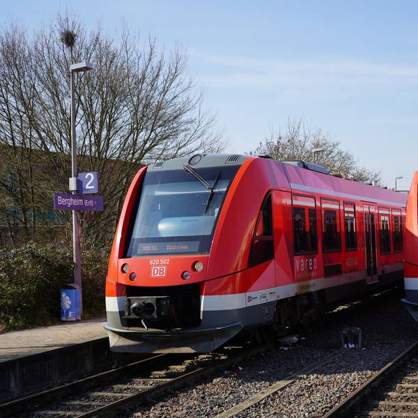 Das Bild zeigt zwei Züge am Bahnhof in Bergheim.