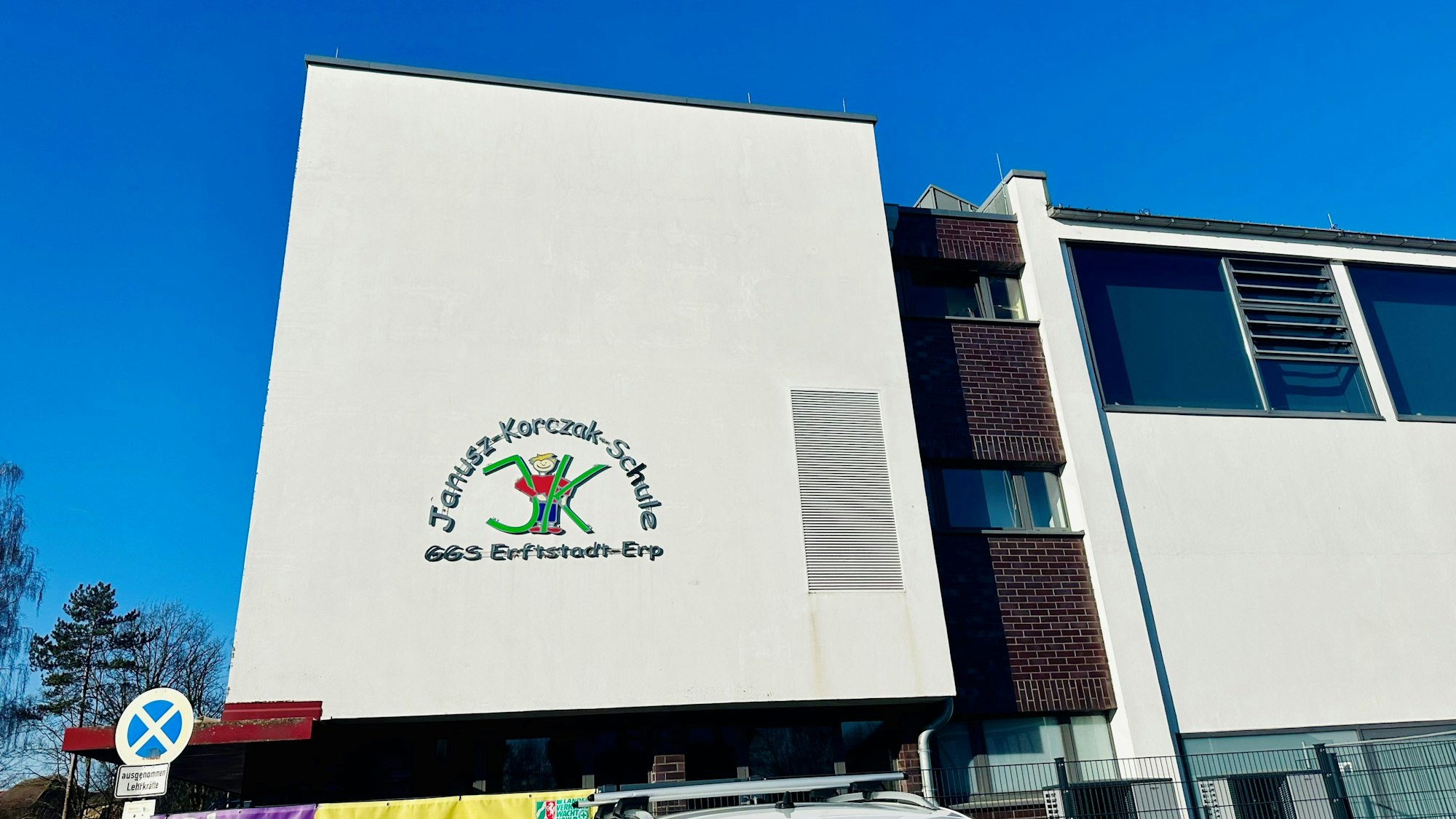 Zu sehen ist ein weißes Grundschulgebäude.