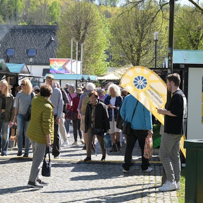 Viele Menschen auf einem Markt mit Ständen.