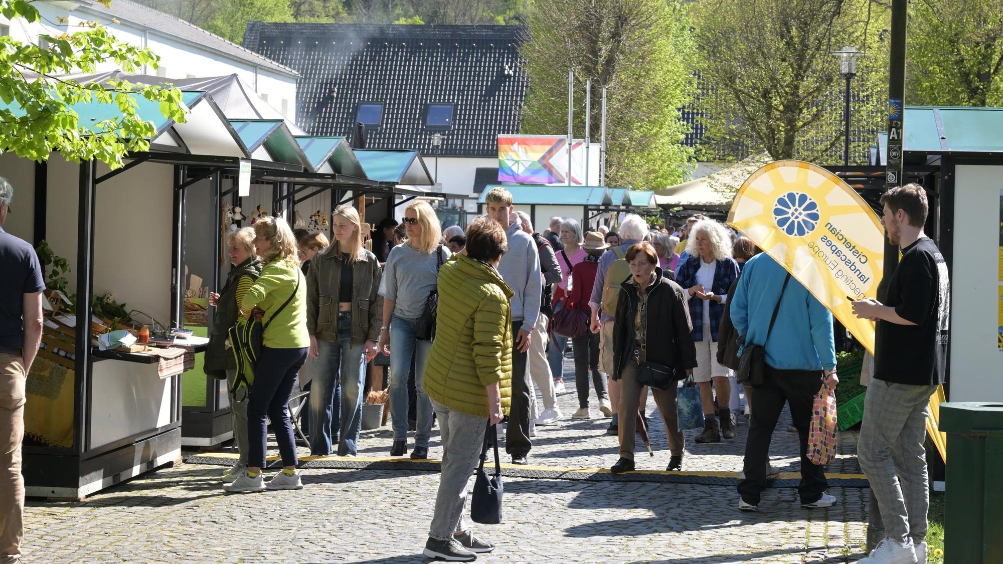Viele Menschen auf einem Markt mit Ständen.