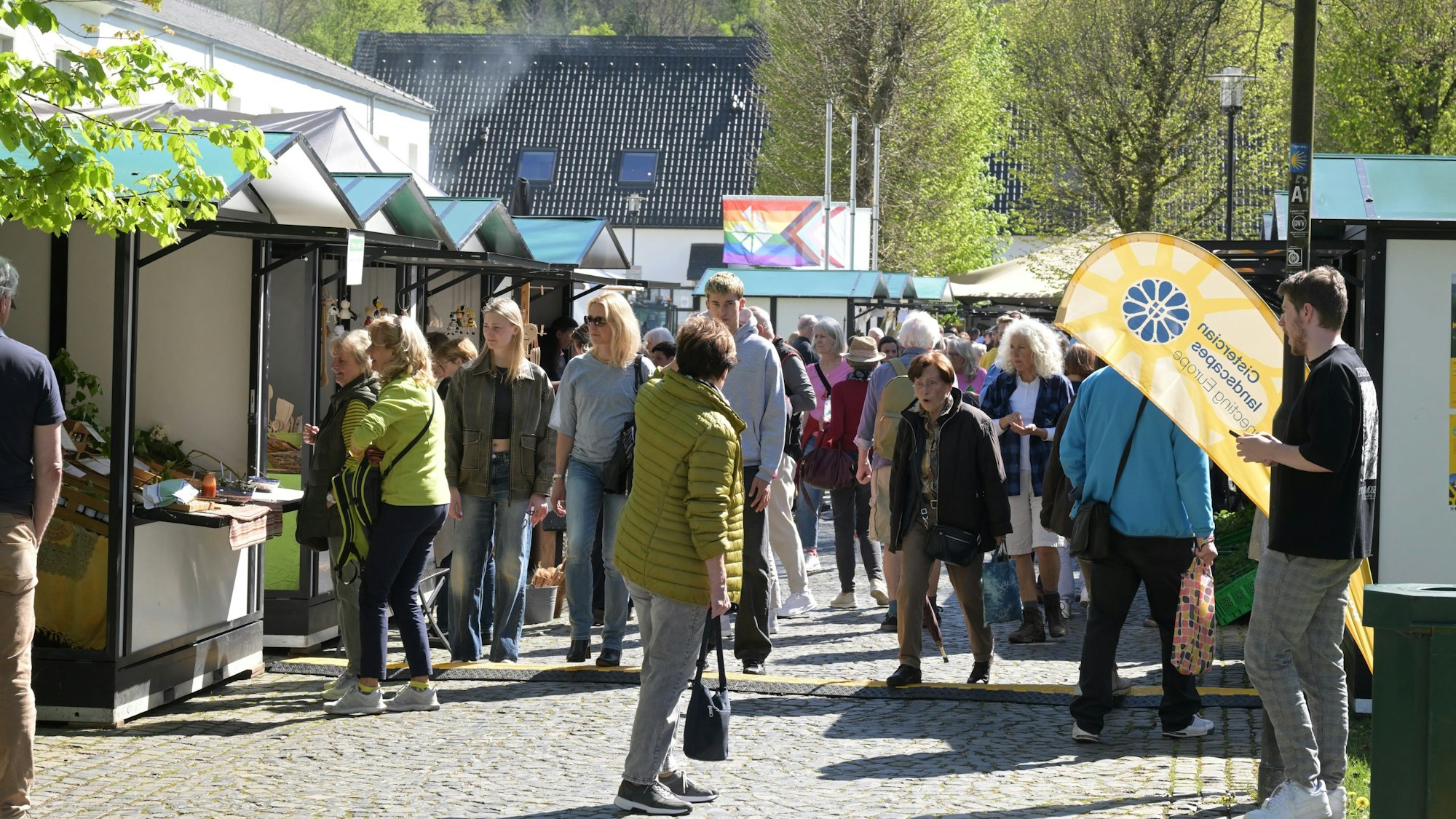Viele Menschen auf einem Markt mit Ständen.