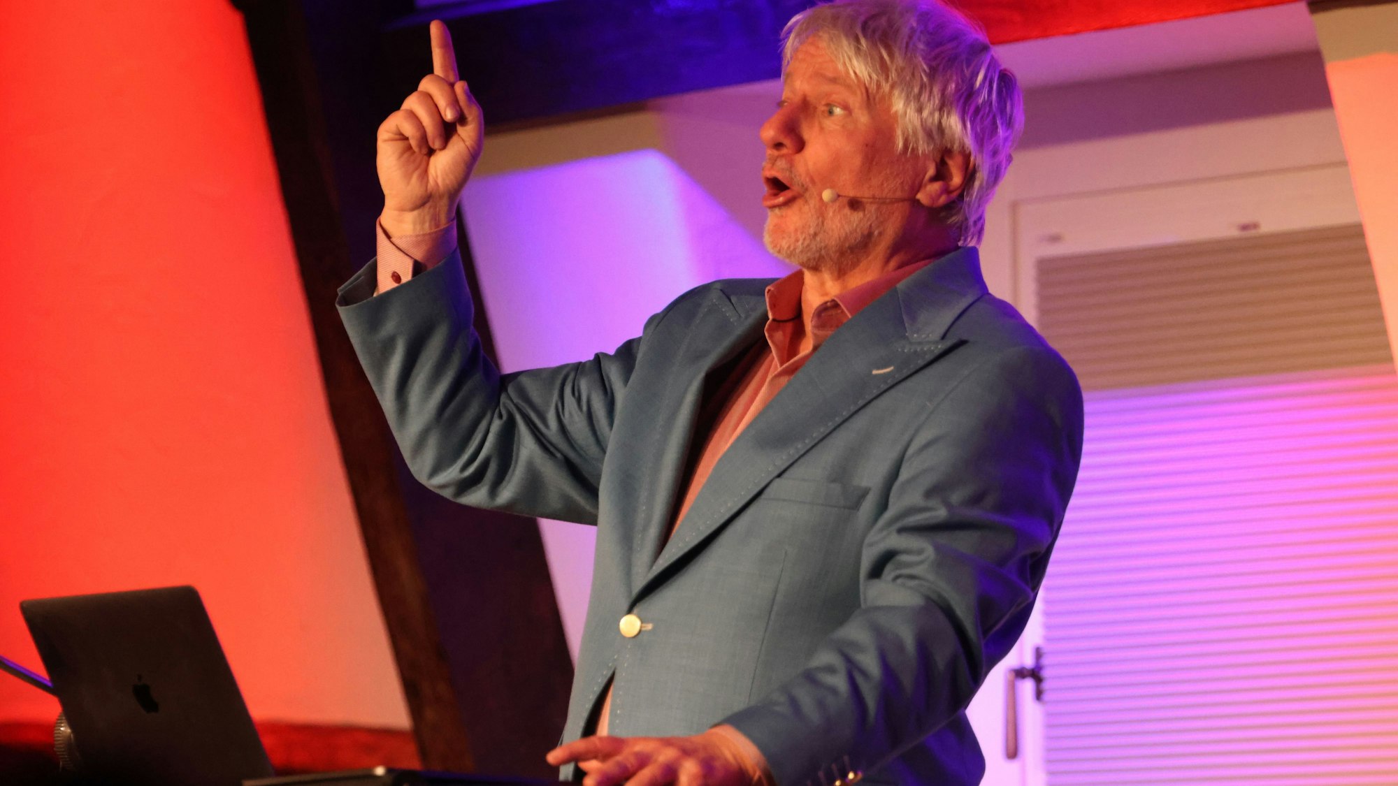 Ein Mann steht an einem Laptop und gestikuliert.