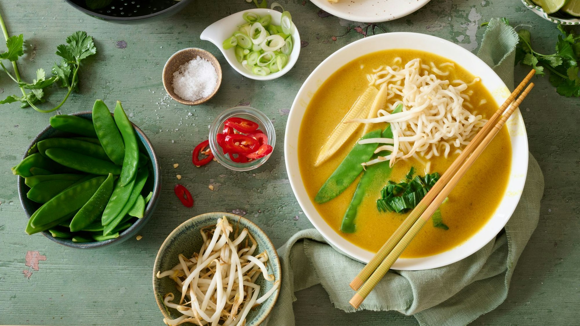 Leuchtendes Gelb und knackiges Grün tritt auf Kokosmilch und Babymais: Diese thailändische Gemüsesuppe bringt einen Hauch Fernost in die Suppenschüssel.