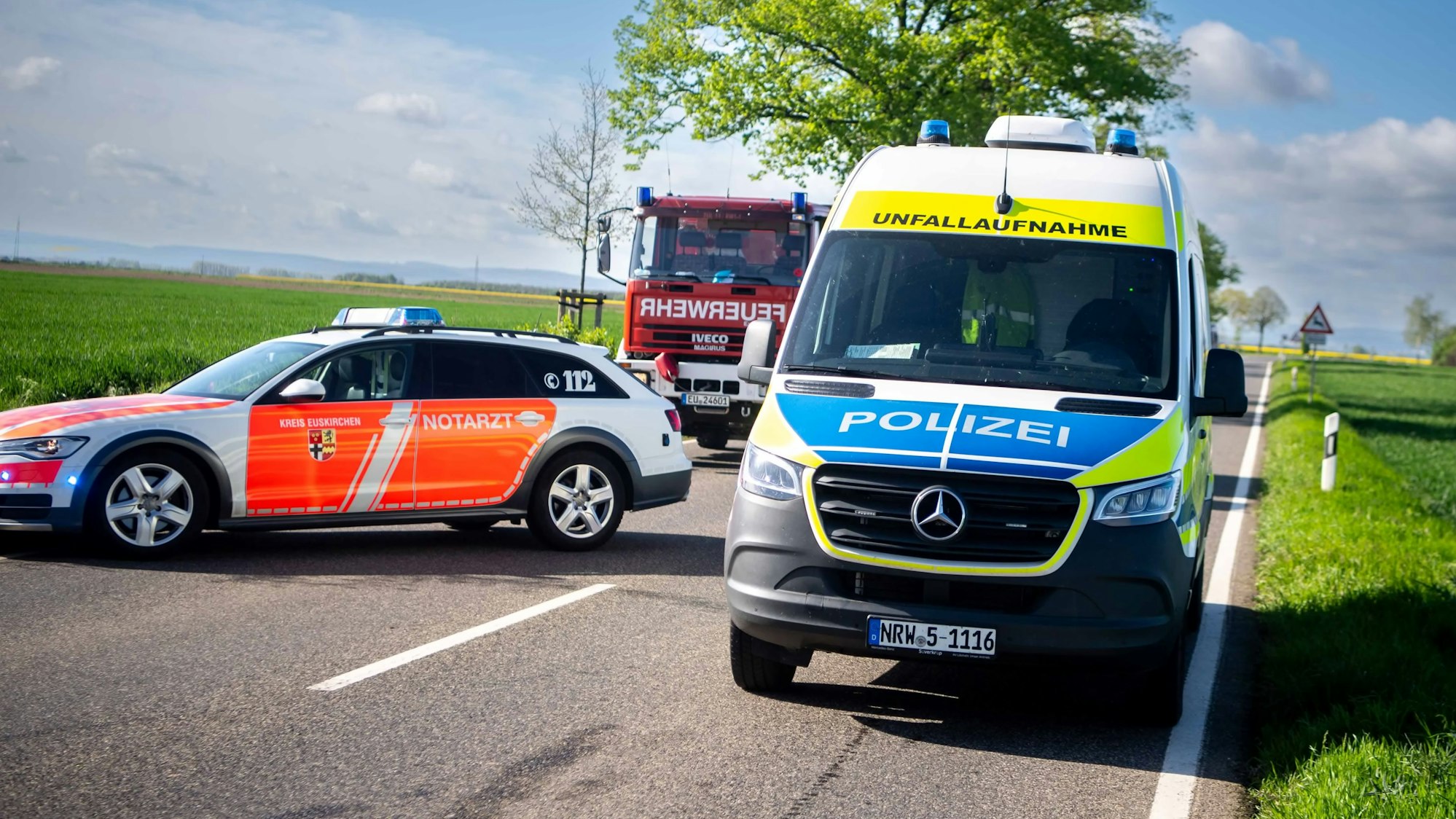 Das Bild zeigt ein Fahrzeug des Rettungsdienstes, der Feuerwehr und der Polizei an einer Einsatzstelle im Kreis Euskirchen.