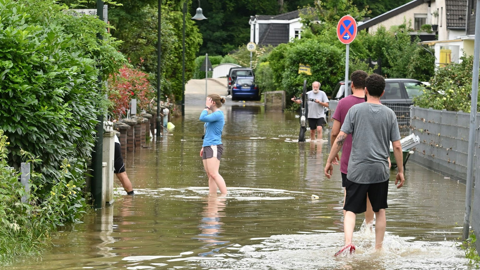 Menschen laufen über eine überflutete Straße
