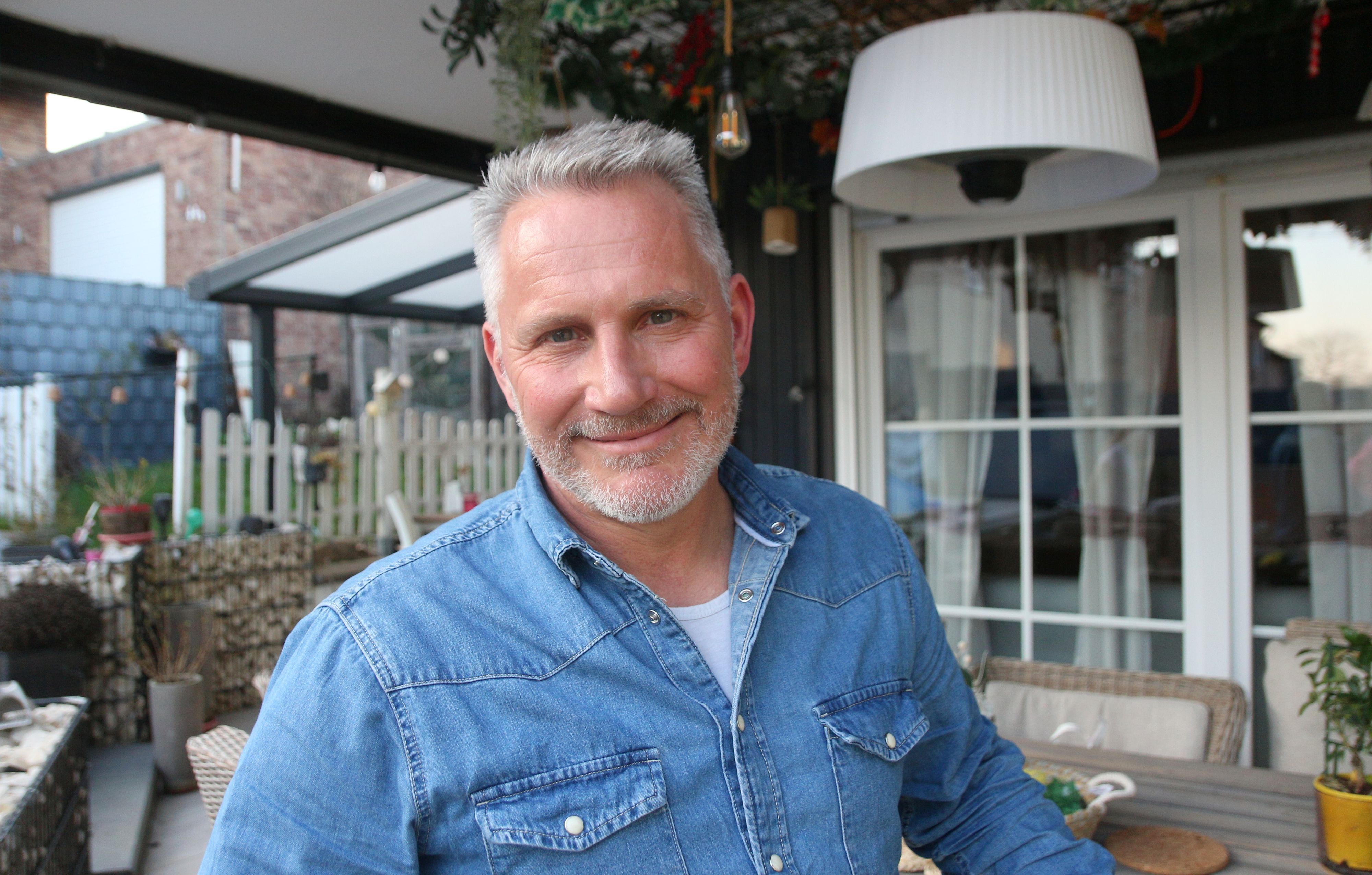 Ein Mann mit Bart lächelt  in die Kamera.