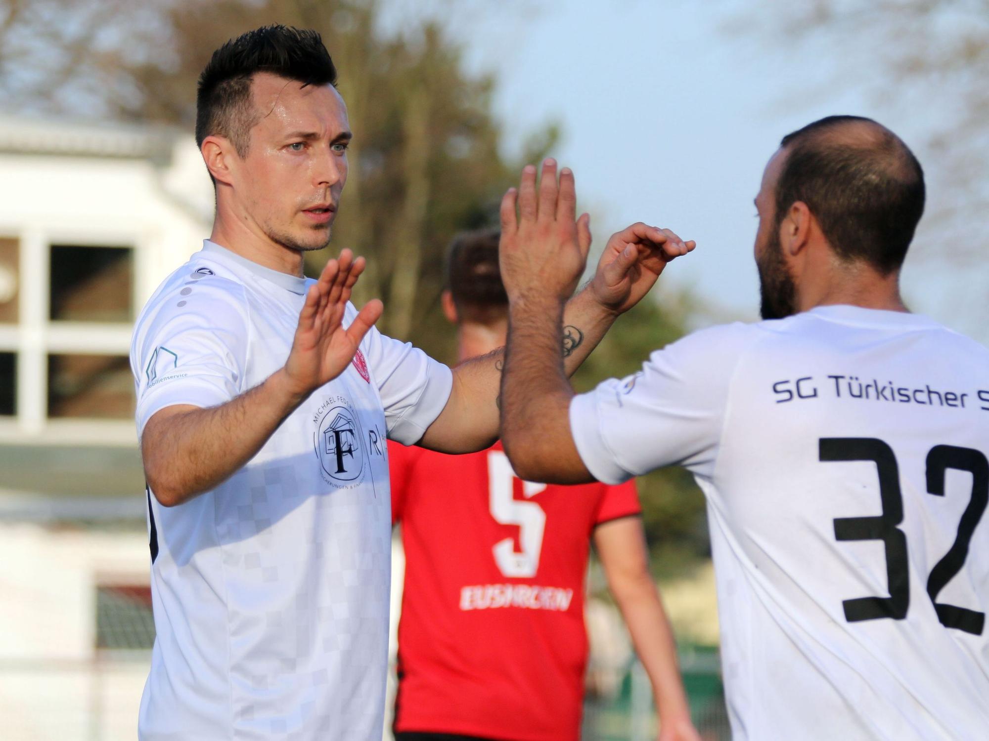 Adam Matuschyk klatscht mit einem Mitspieler ab.