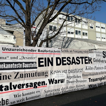 „Totalversagen“: Schlagzeilen zum Baudebakel finden sich am Zaun vor dem Offenbachplatz.