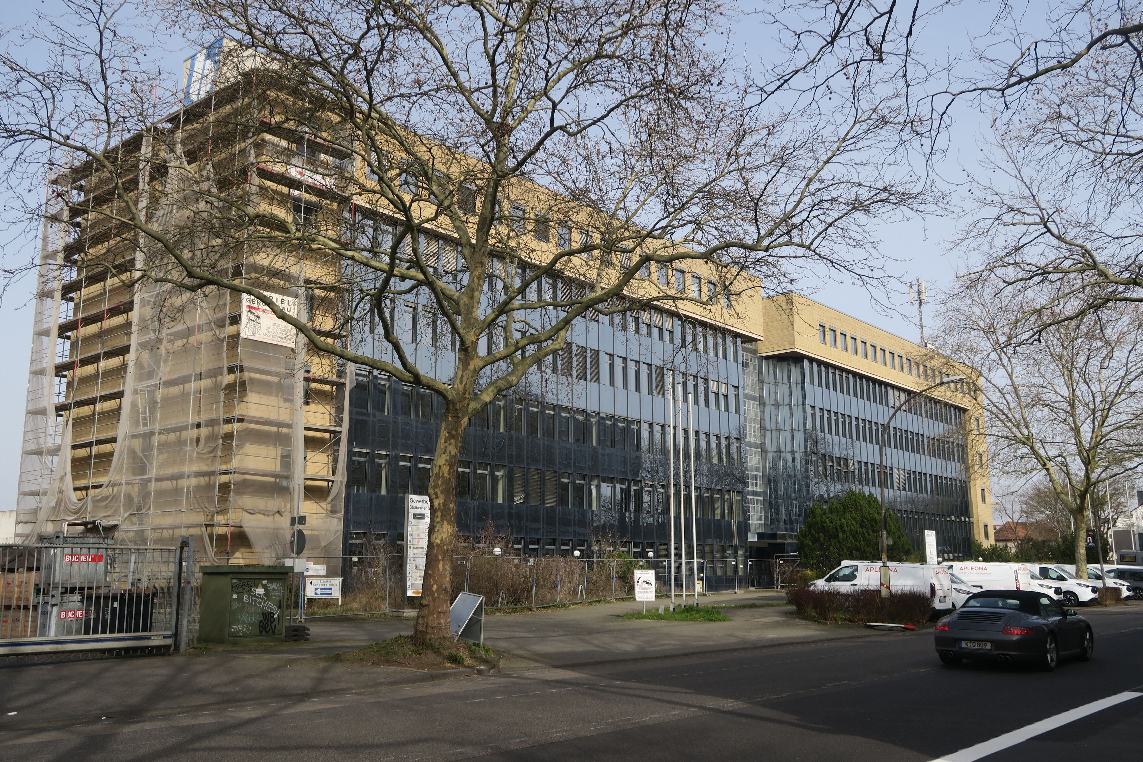 An einer Straße steht ein mehrstöckiges Gebäude.