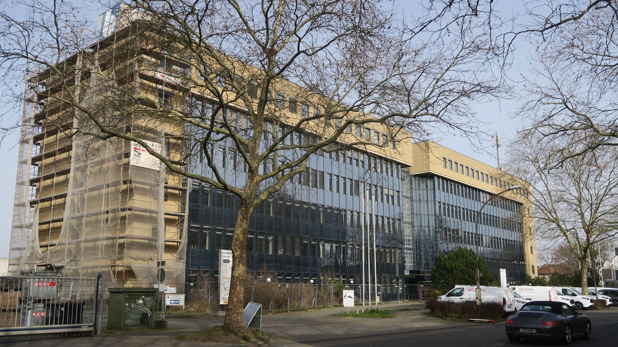 An einer Straße steht ein mehrstöckiges Gebäude.