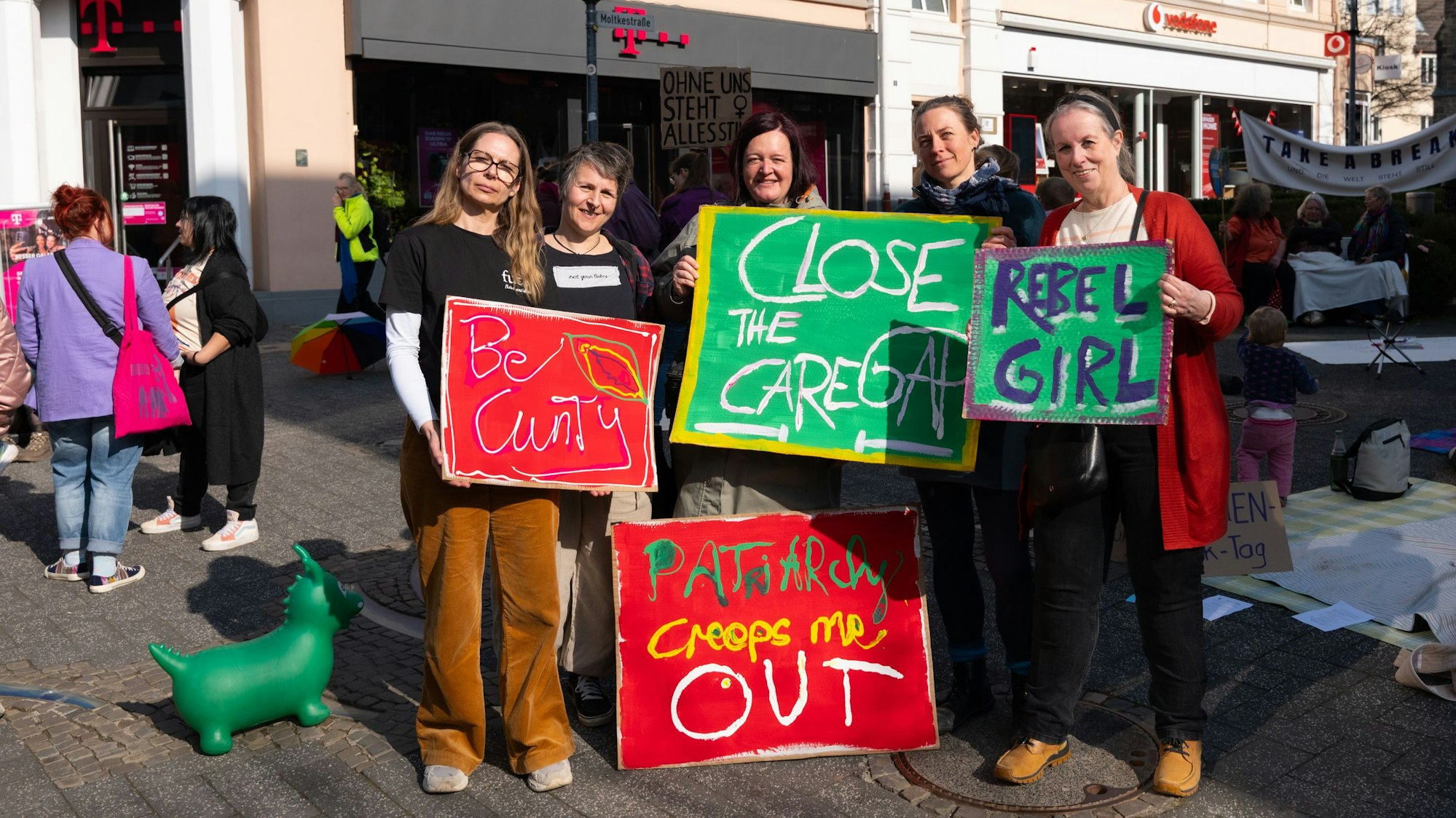 Fünf Frauen mit bunten Plakaten für Frauenrechte auf dem Lindenplatz in Gummersbach.