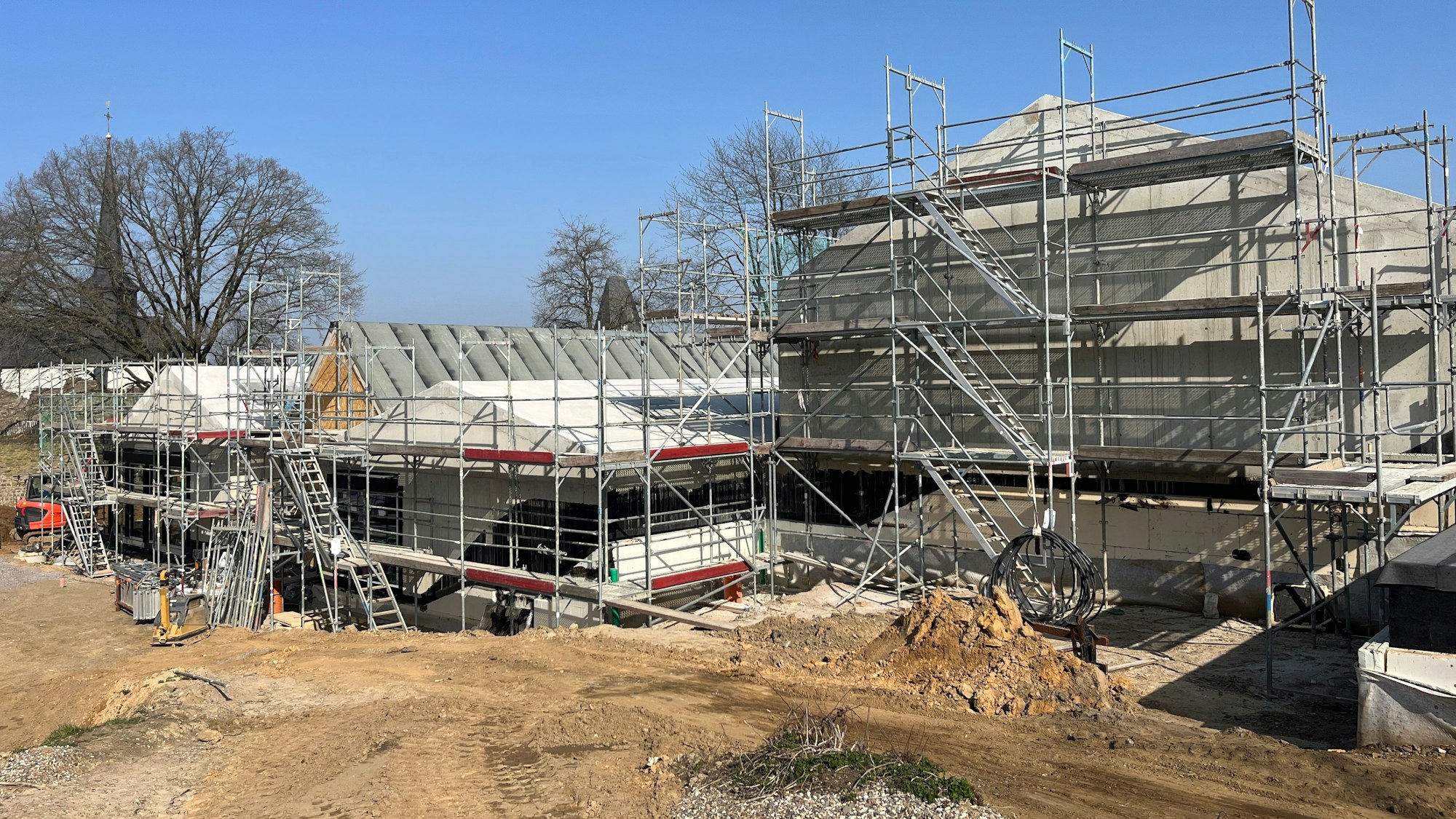 Deutlich zu erkennen sind die unterschiedlichen Dachneigungen und Größen der Baukörper, die aneinandergesetzt sind und ein Dorfbild symbolisieren.