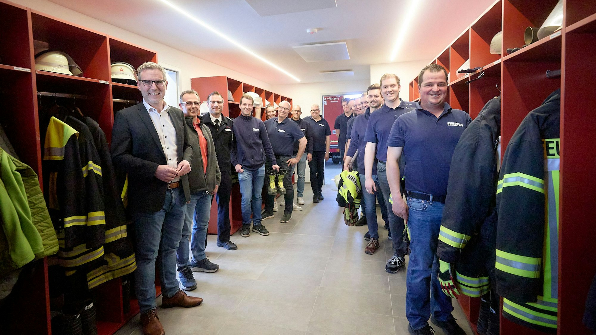 Eine Gruppe von Männern steht im Umkleidebereich des Feuerwehrhauses in Roderath.