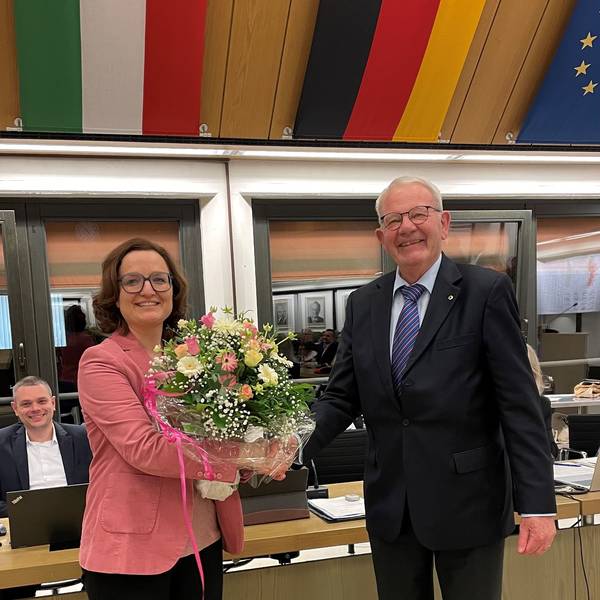 Das Foto zeigt Sabine Schüller, die einen Blumenstrauß entgegennimmt.