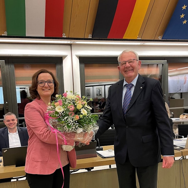 Das Foto zeigt Sabine Schüller, die einen Blumenstrauß entgegennimmt.