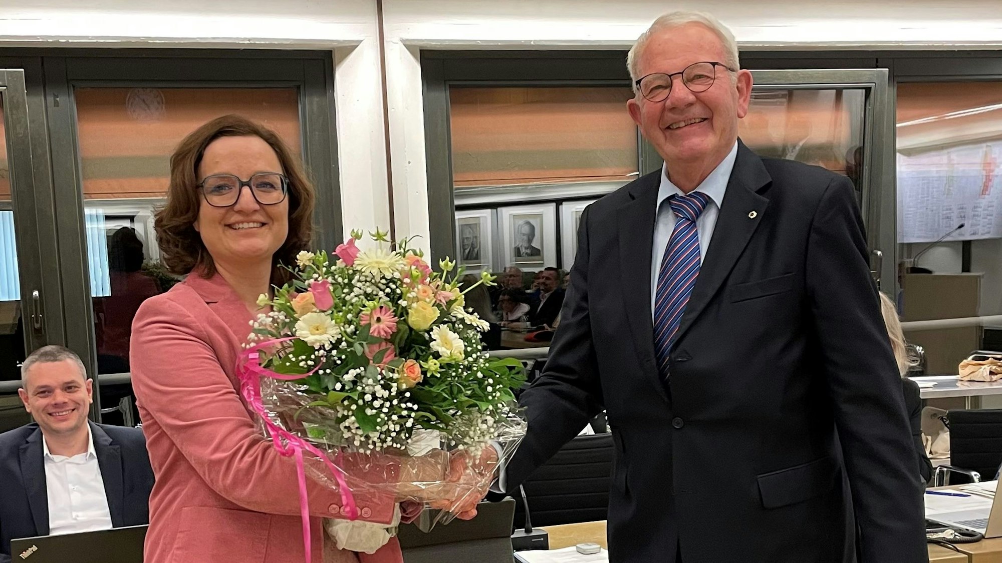 Das Foto zeigt Sabine Schüller, die einen Blumenstrauß entgegennimmt.