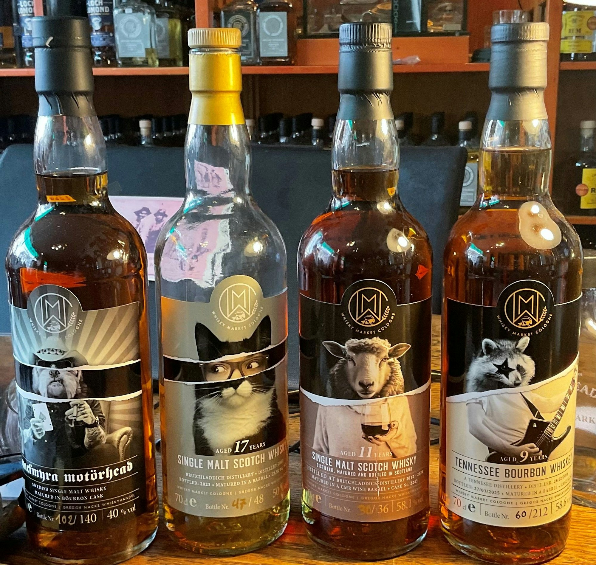 Vier Whisky- oder Bourbon-Flaschen stehen nebeneinander.