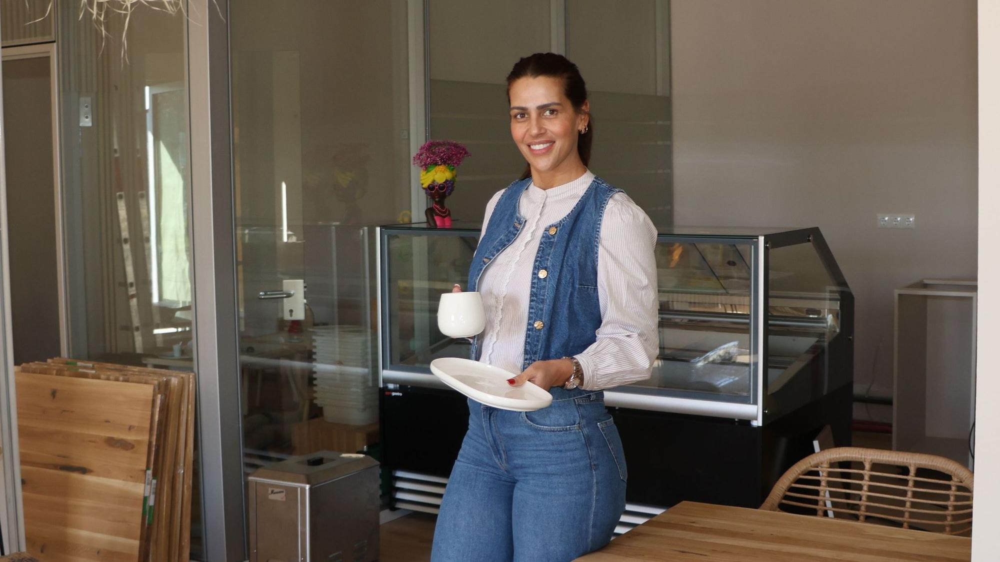 Auf dem Bild ist eine Frau in ihrem neuen Café zu sehen.