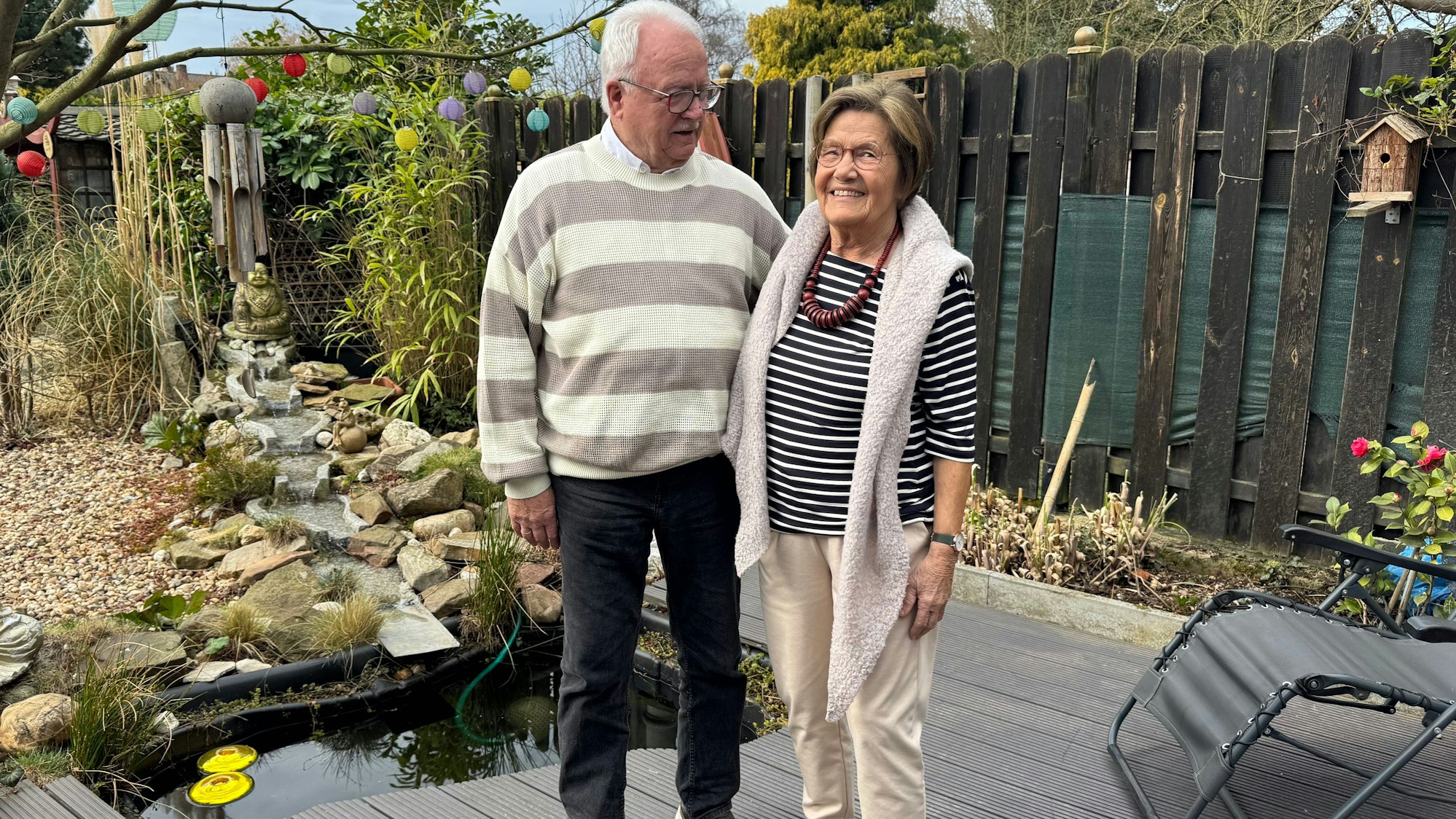 Ein Ehepaar steht in seinem Garten.