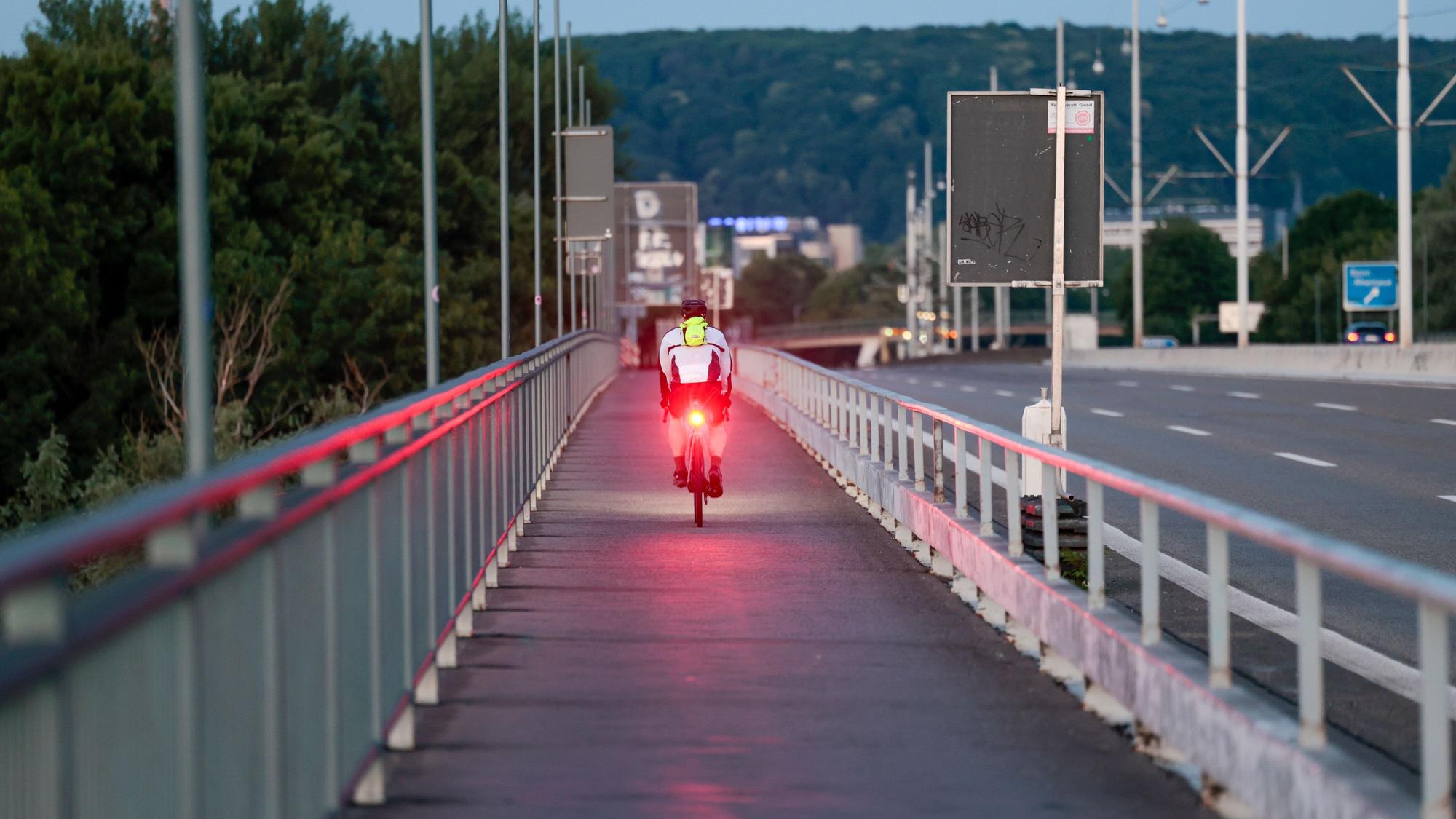 Ein Fahrradfahrer fährt am frühen Morgen über die Südbrücke in Bonn (Archivfoto).