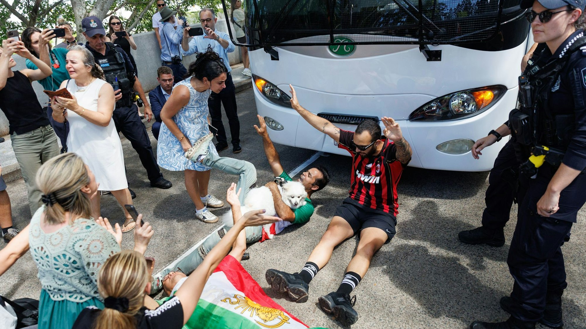 Demonstranten protestierten, während der Bus mit iranischen Spielerinnen und Mitarbeitern abfuhr.