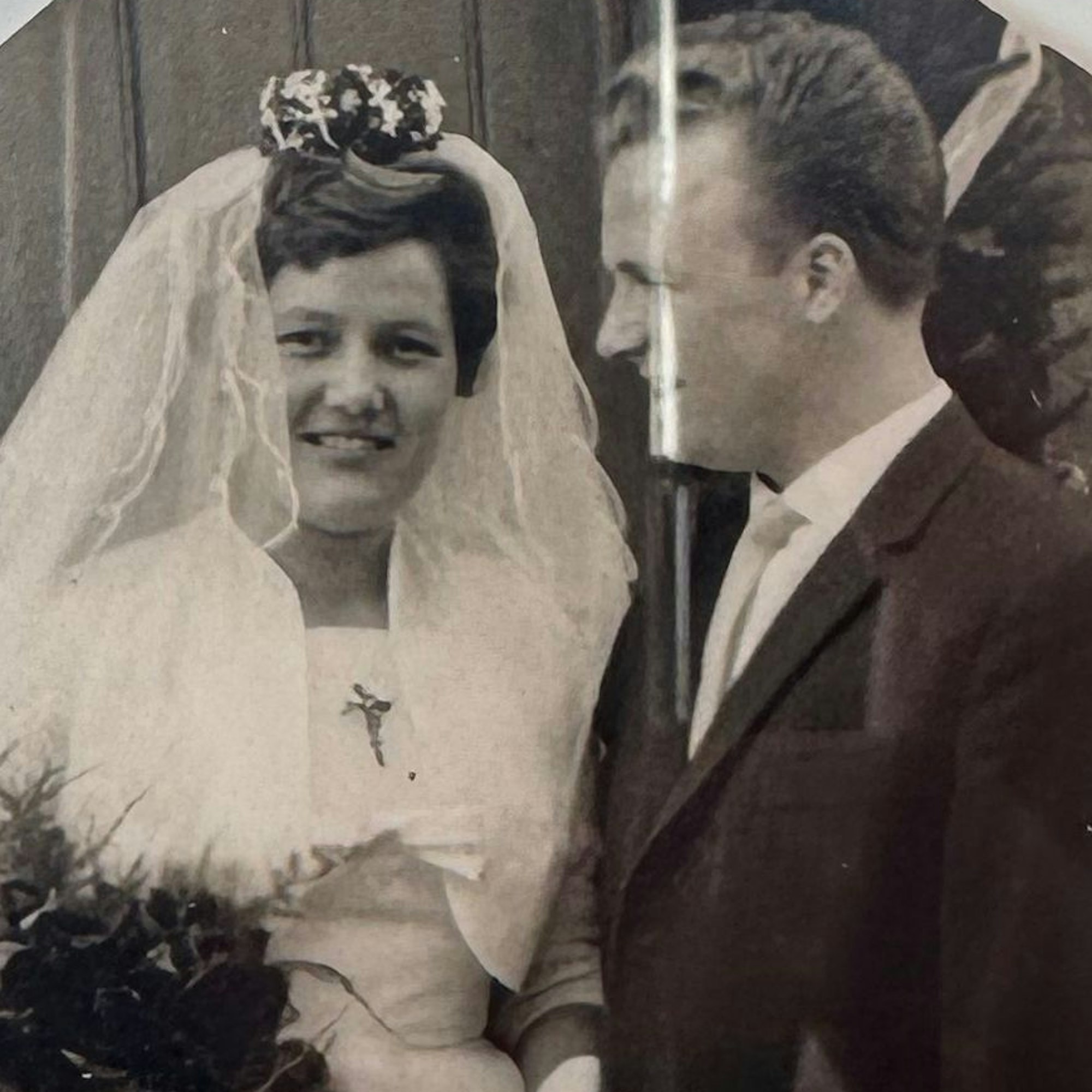 Zu sehen ist die Schwarz-Weiß-Aufnahme eines Ehepaares am Tag seiner Hochzeit.