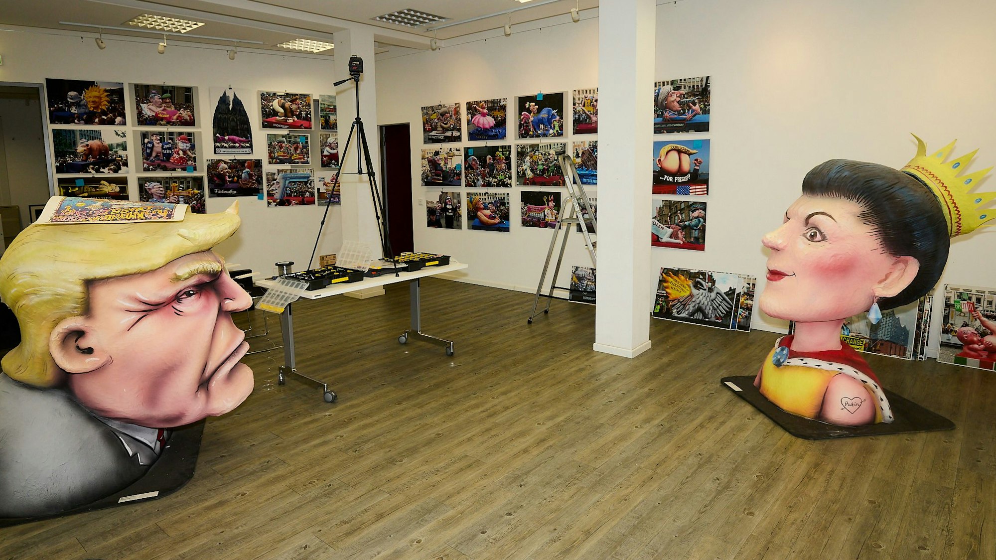 Aug in Aug stehen sich die Köpfe von Trump und Wagenknecht gegenüber, an den Wänden dahinter hängen Fotos.