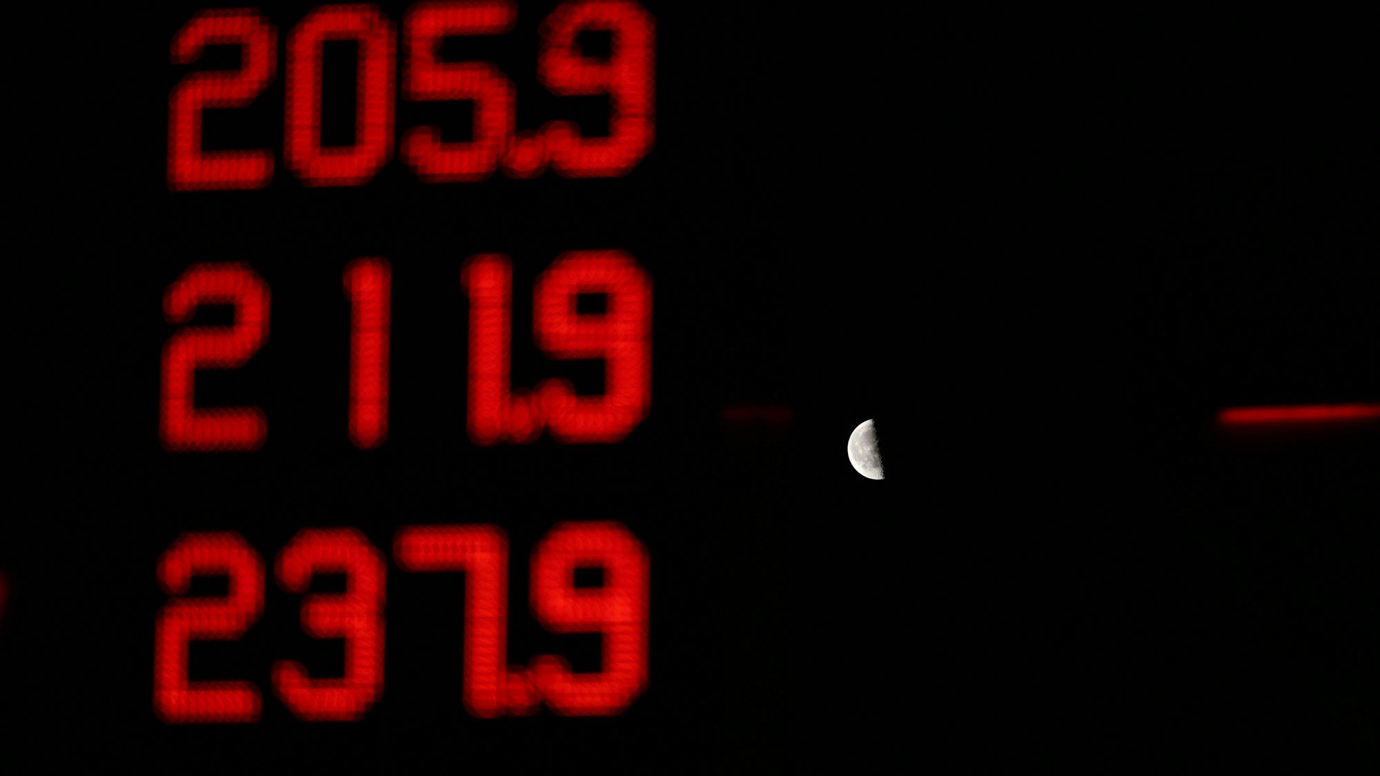 Deutlich über zwei Euro pro Liter liegen am Morgen alle angebotenen Spritsorten an einer Tankstelle, die vor dem Mond auf einer Tafel zu sehen sind. (Symbolbild)