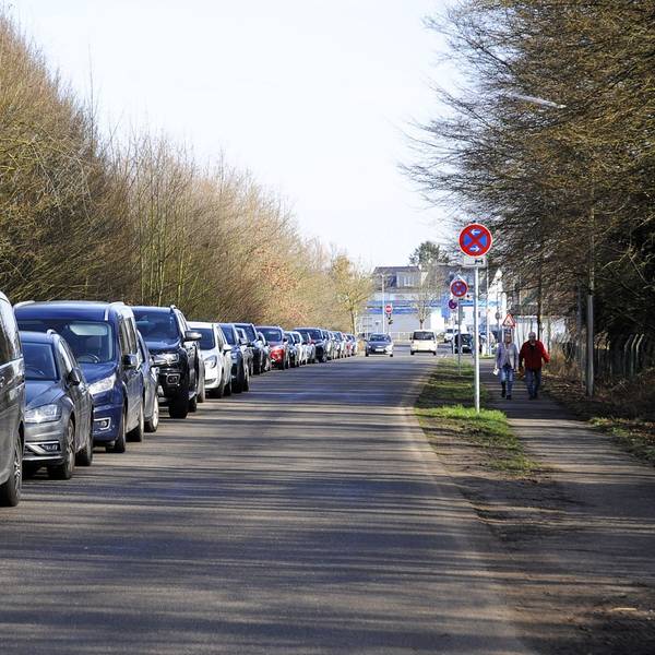 Autos stehen an einer Straße entlang.