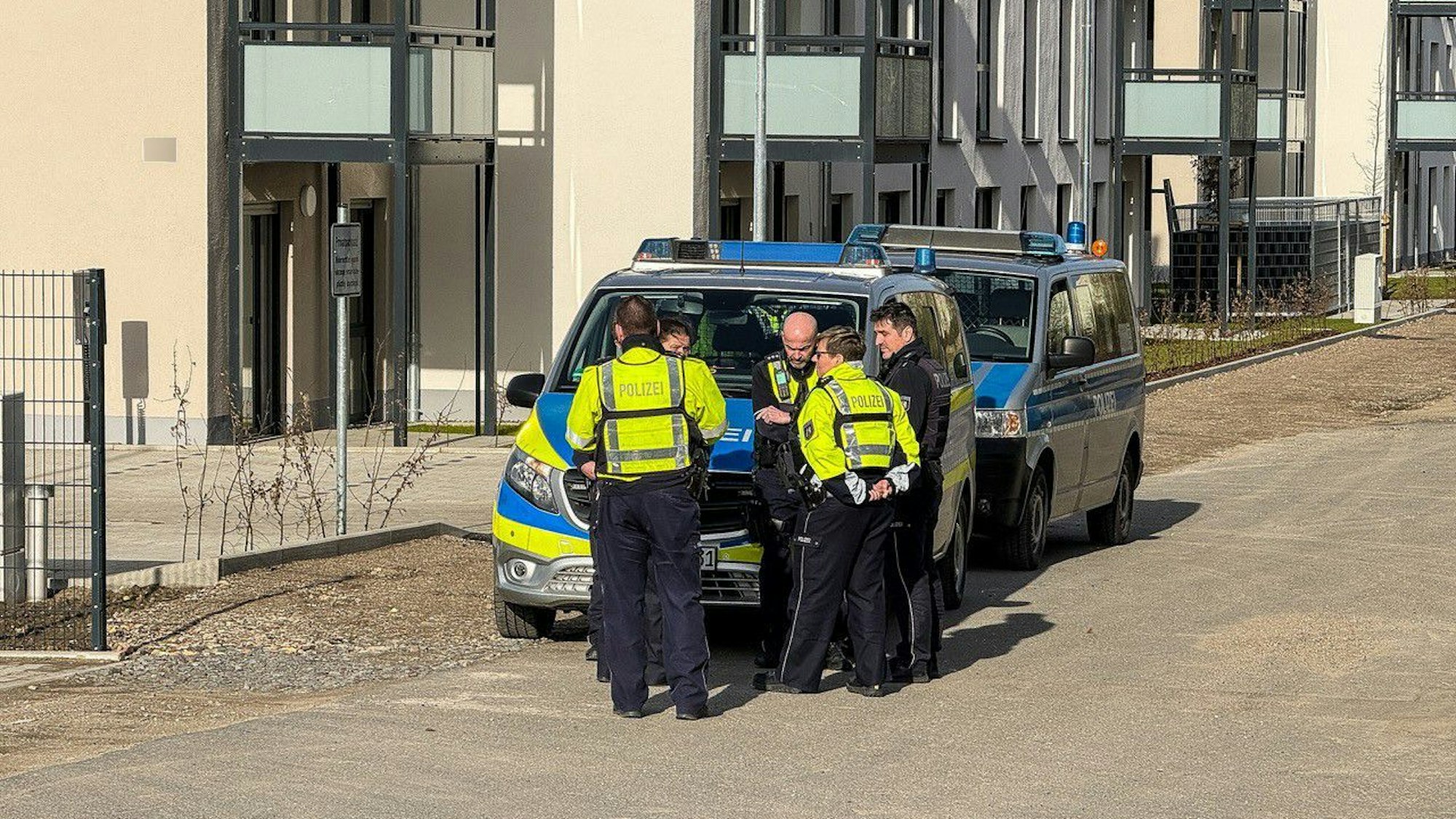 Gevelsberg: Polizisten stehen vor einem Polizeiauto. Nach einer mutmaßlichen Entführung in Gevelsberg bei Hagen suchen die Beamten nach einem Auto.