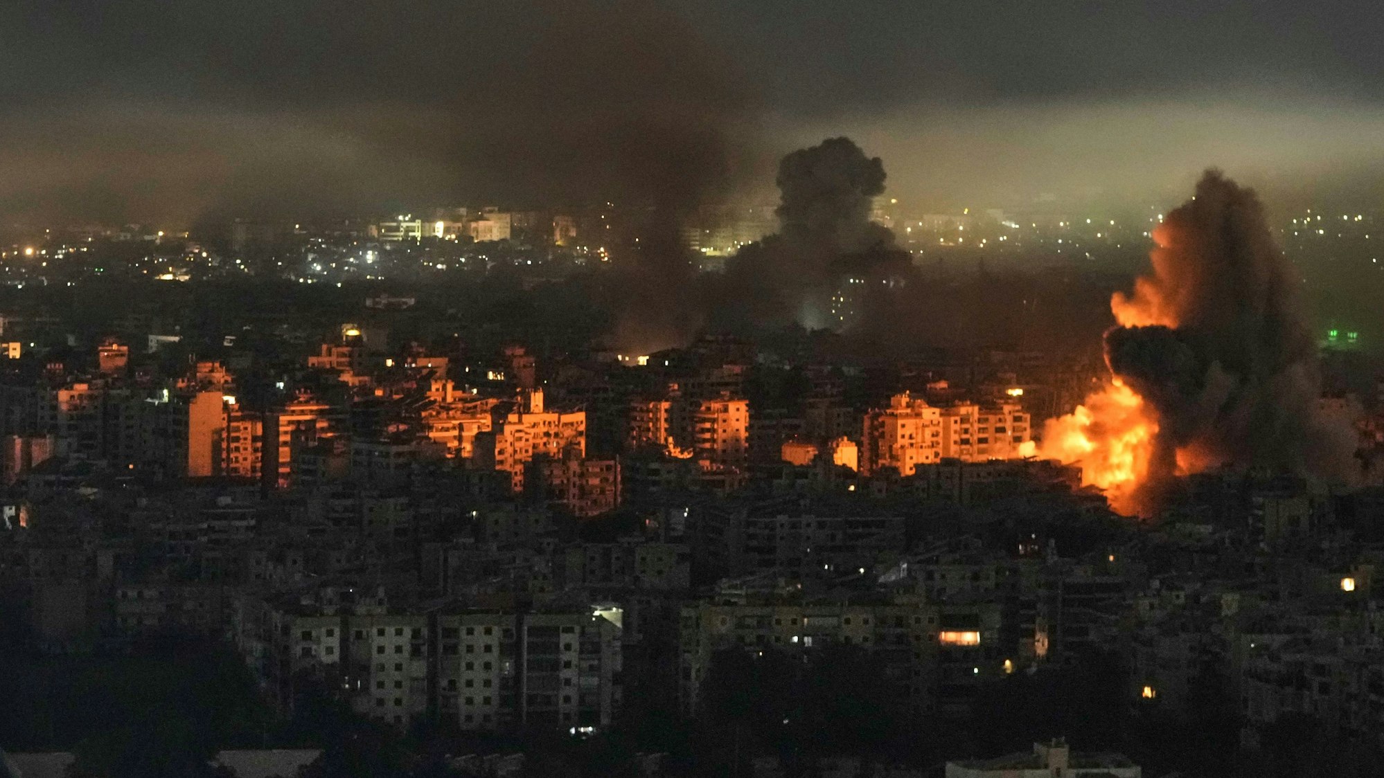 11.03.2026, Libanon, Beirut: Rauch und Flammen steigen nach einem israelischen Luftangriff in Dahija, einem südlichen Vorort von Beirut, aus Gebäuden auf. Foto: Bilal Hussein/AP/dpa +++ dpa-Bildfunk +++