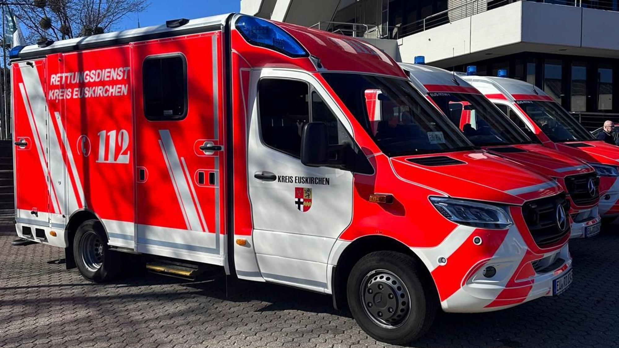 Ein Rettungswagen und zwei Krankentransportwagen stehen vor dem Kreishaus in Euskirchen.