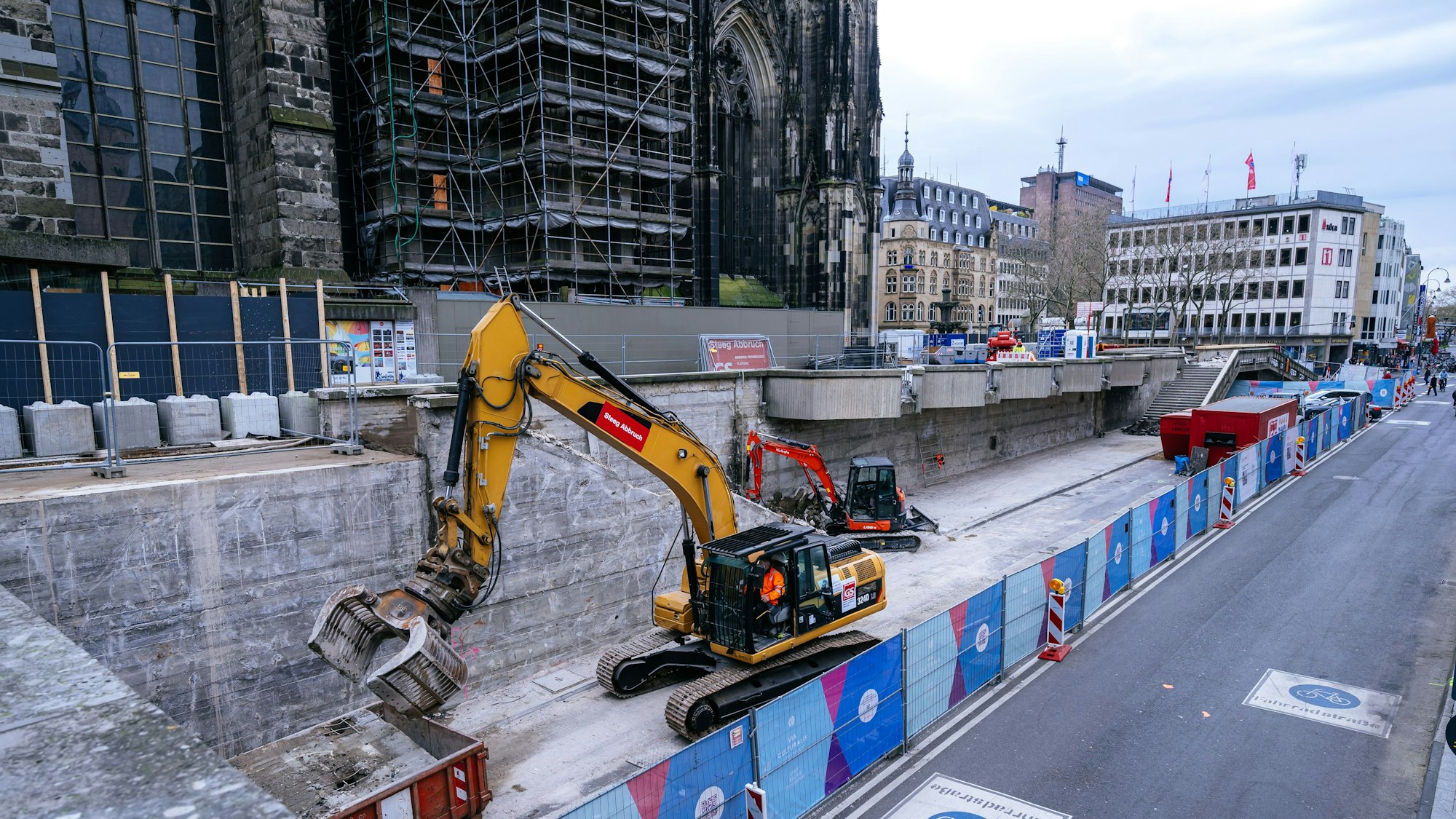 Der Bagger mit der großen hydraulischen Zange nimmt die Brüstungsteile ab.