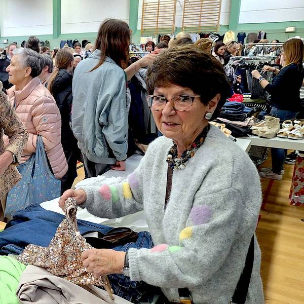 Zwei Frauen stehen in Mechernich an einem Flohmarktstand mit Kleidung.