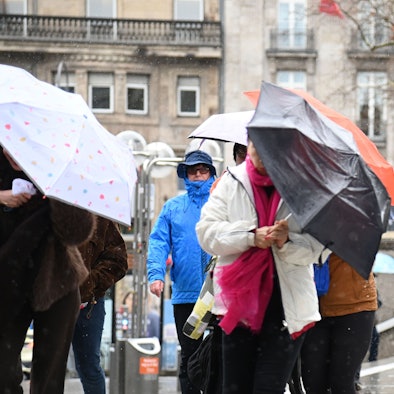 Menschen schützen sich auf der Domplatte in Köln vor Regen und Wind. (Archivfoto)