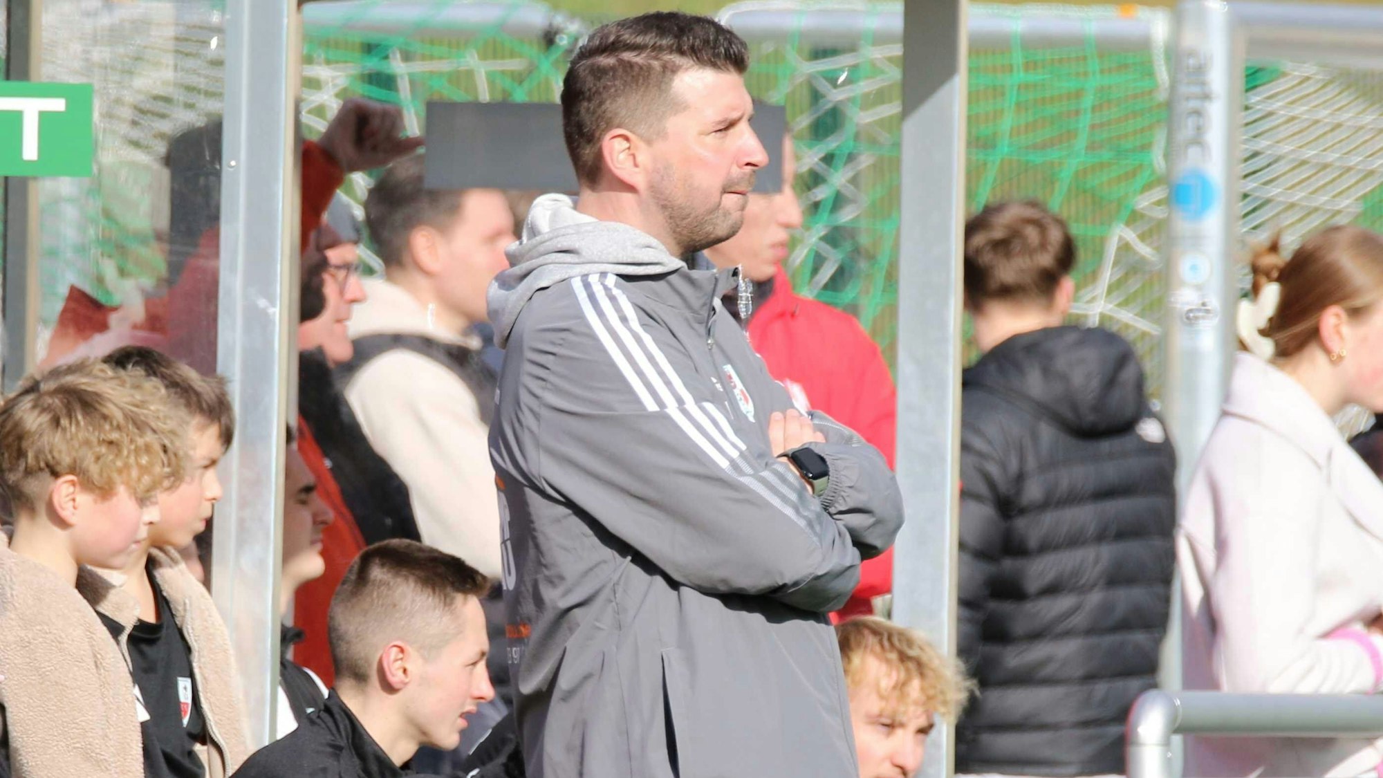 Christian Hammes steht an der Seitenlinie und hat die Arme verschränkt.