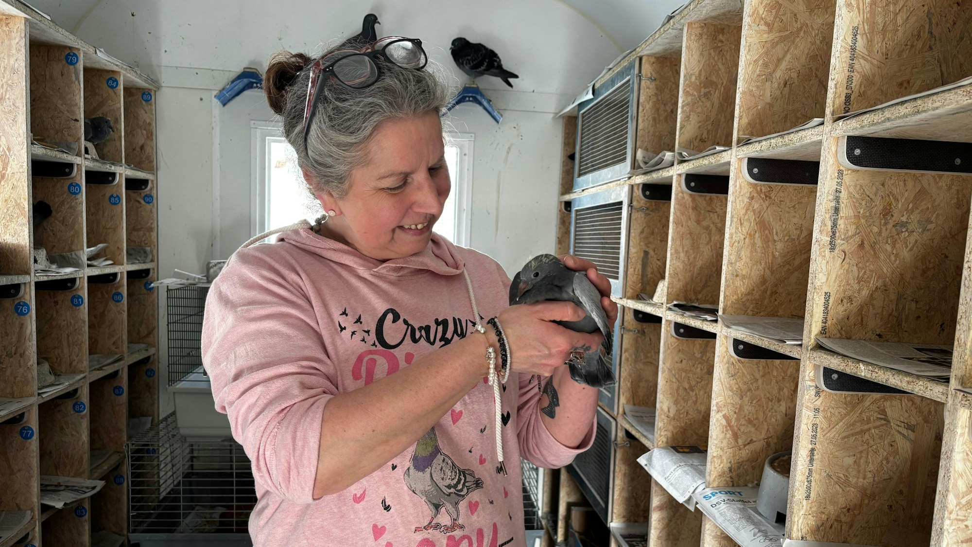 Eine Frau hält eine junge Taube in den Händen.