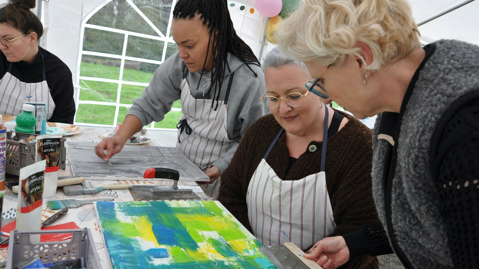 Das Foto zeigt die Künstlerin mit Teilnehmerinnen des Workshops.