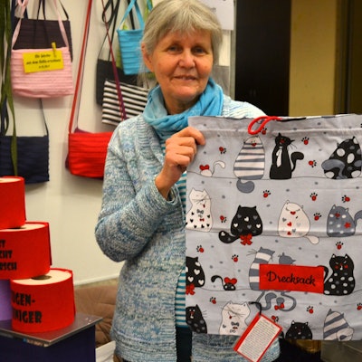 Eine Frau hält einen Wäschebeutel in der Hand.