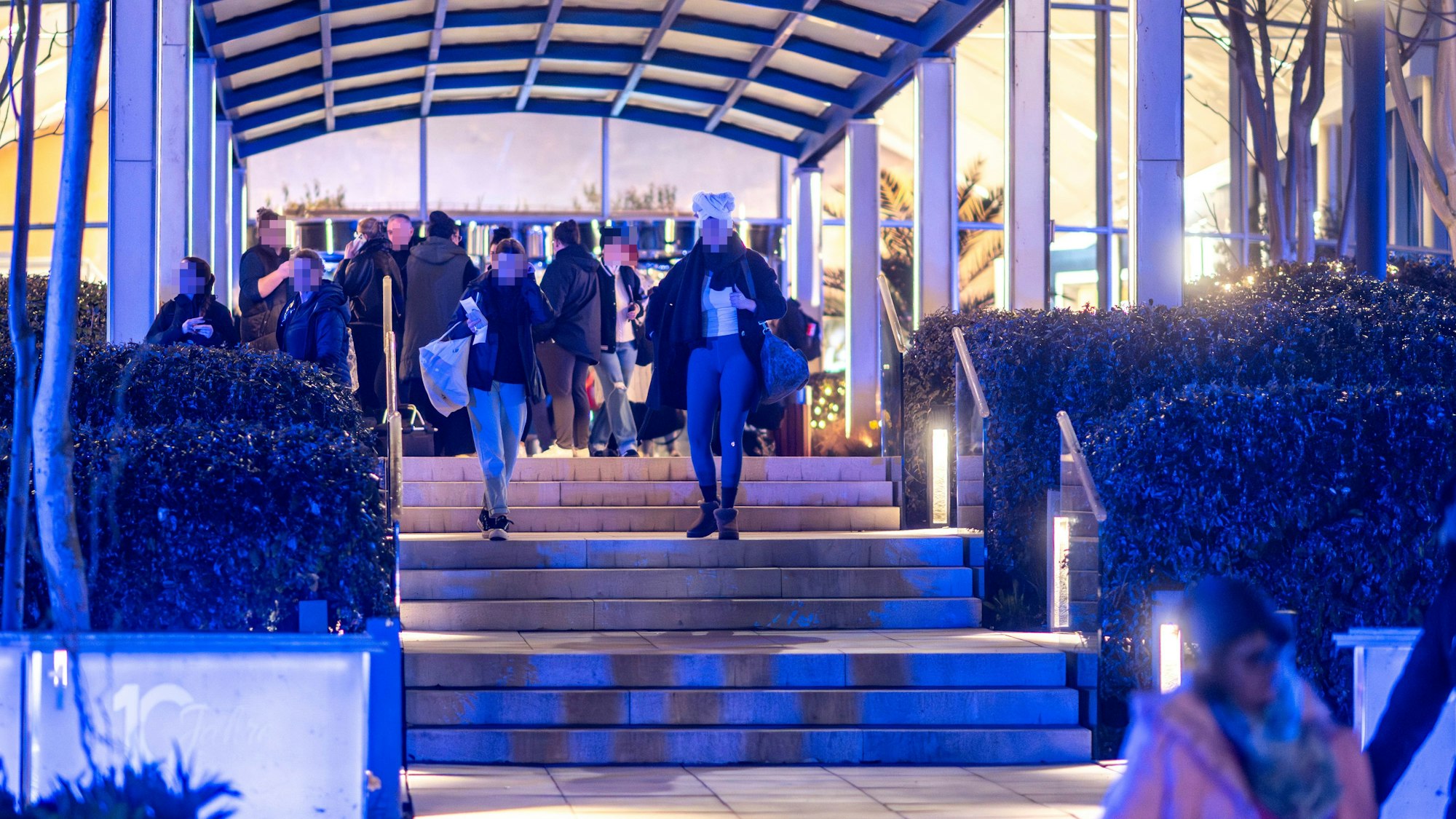 Menschen gehen aus einem Gebäude heraus.