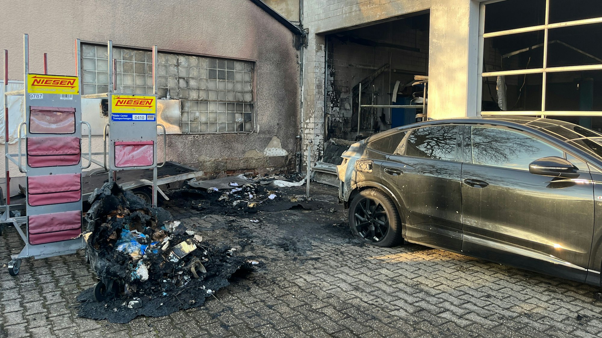 Das E-Auto brannte im Heck. Die Flammen schlugen in die Werkstatt über.