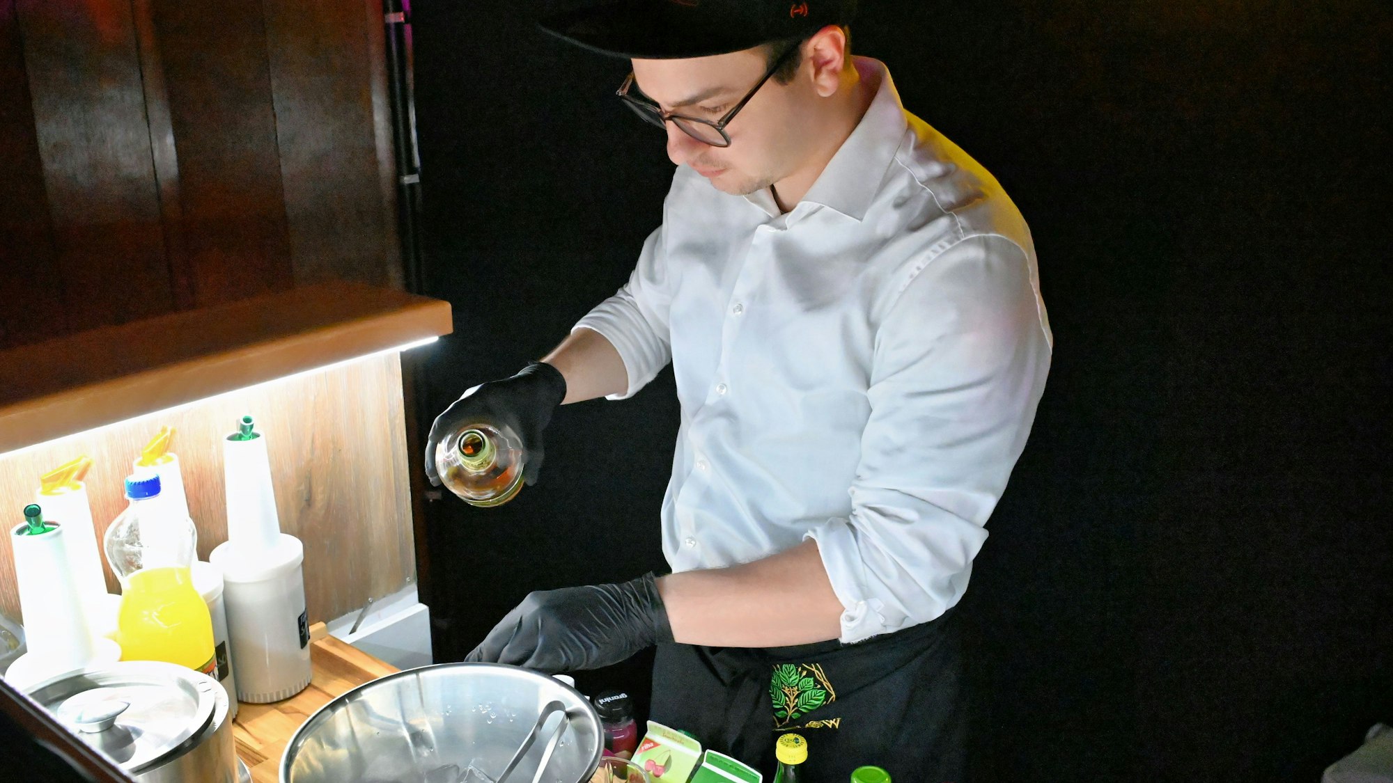 Alexander Bigelmaier mixt hinter einem Tresen einen Cocktail.