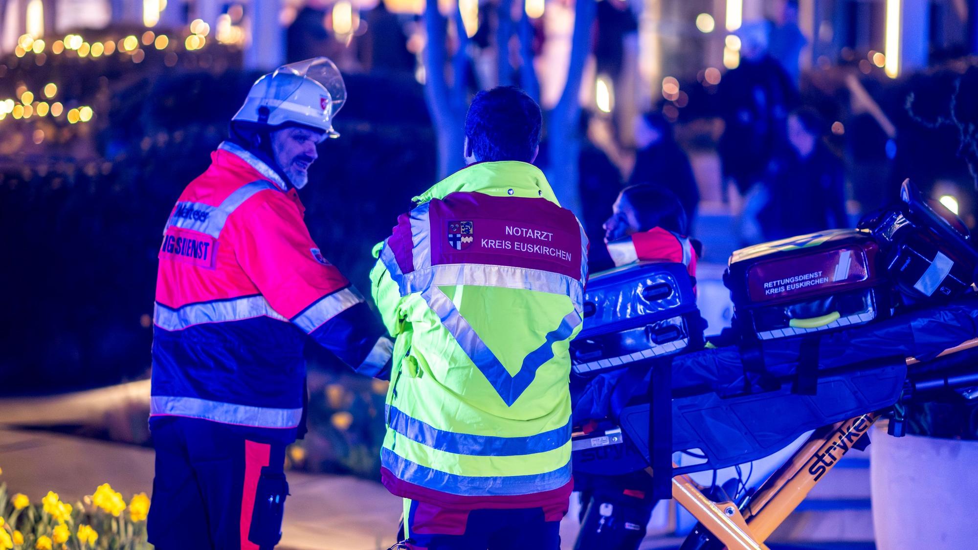 Ein Notarzt und ein Rettungssanitäter stehen neben einer leeren Trage.