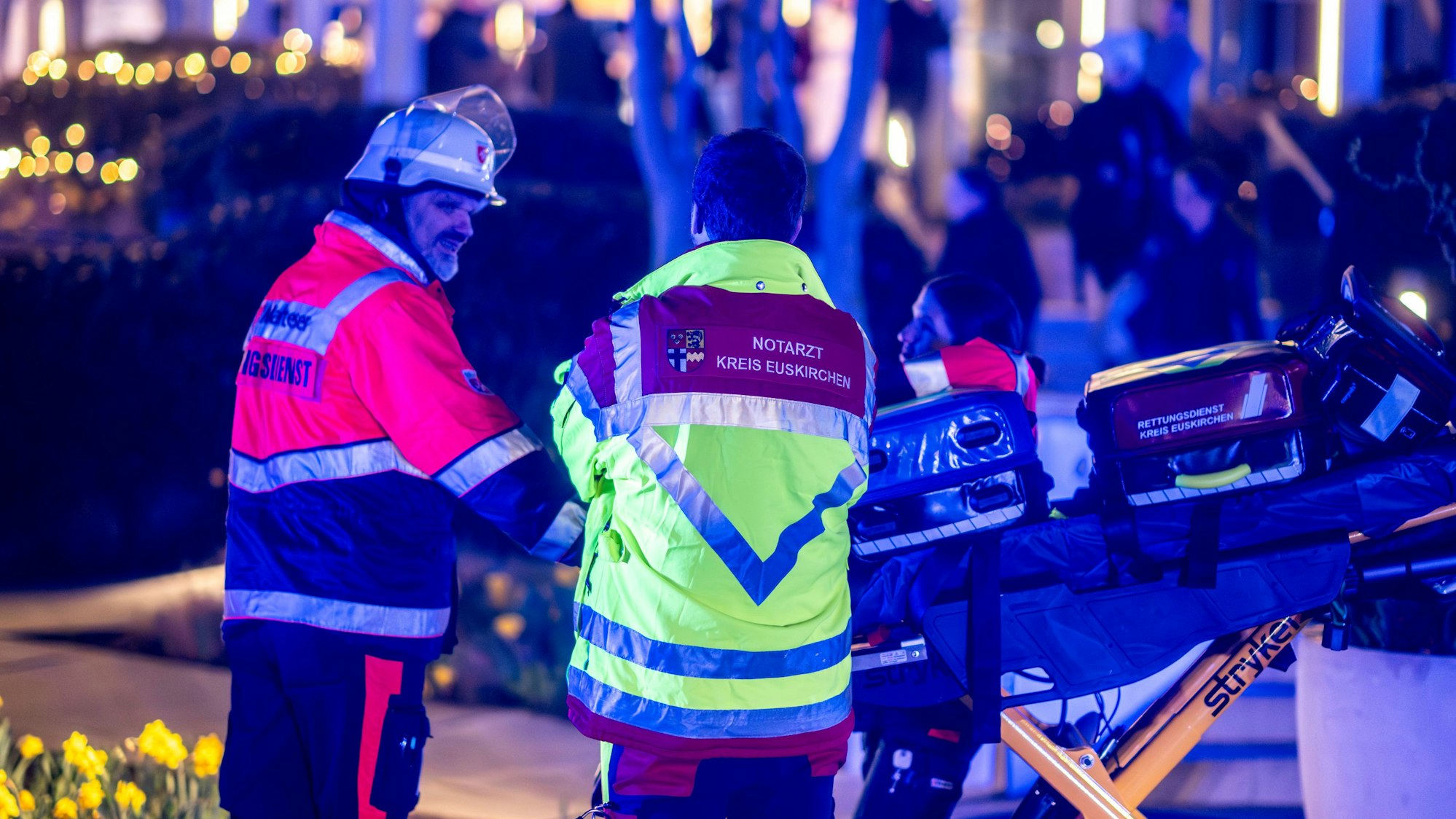 Ein Notarzt und ein Rettungssanitäter stehen neben einer leeren Trage.