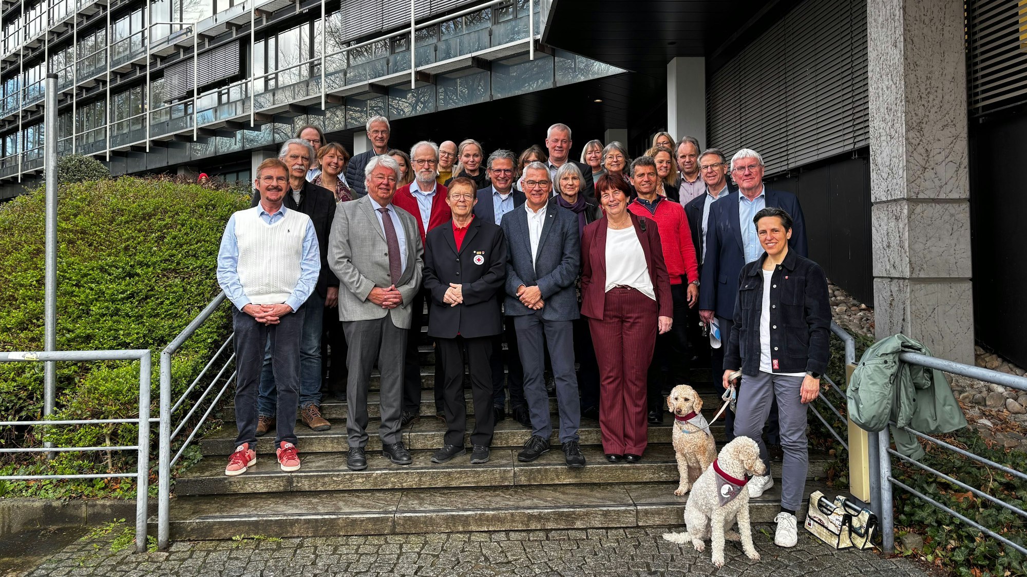 Männer und Frauen stehen auf der Treppe vor dem Siegburger Kreishaus.