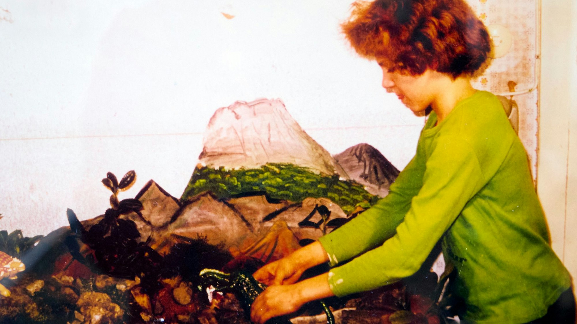 Jacques Tilly im grünen Pullover mit lockigem Haar beim Kulissenbau für einen Film.